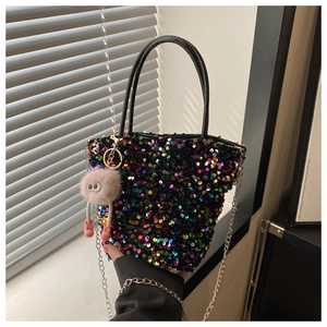 Détail du sac à main à paillettes colorées avec charme en fourrure et chaîne