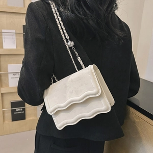 Minimalist beige crossbody bag with wave pattern flap and elegant silver chain strap