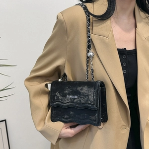 Vintage black crossbody bag with wave pattern flap and silver chain strap for women