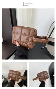 Detail of brown quilted tote bag showing square stitching and soft padded nylon texture