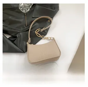 Detailed size comparison of beige crocodile pattern handbag with gold chain strap accessory