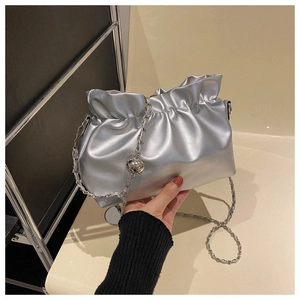Close-up of silver pleated bucket bag with metallic chain and stylish ball ornament