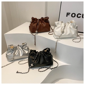 Detailed view of gathered cloud bags in brown, white, silver, and black with metal chains
