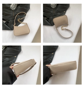 Detail view of beige crocodile embossed baguette bag with gold chain and slim strap