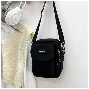 Detail of black nylon crossbody bag with fashion label on front pocket for outdoor use