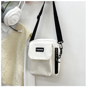 Detail view of white nylon crossbody bag with fashion label, side zipper, and black chain