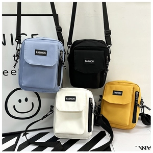 Detailed view of colorful nylon crossbody bags in blue, black, white, and yellow