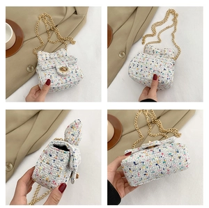 Macro details of mini tweed plaid bag with golden chain and metallic twist lock