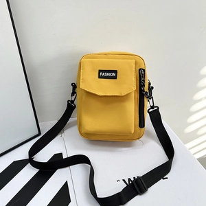Bright yellow canvas crossbody phone bag with adjustable black strap and fashion label