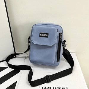 Light blue nylon crossbody phone bag with adjustable strap and fashion patch for casual use