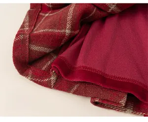 Close-up of red and black plaid wool skirt hem with soft burgundy velvet lining