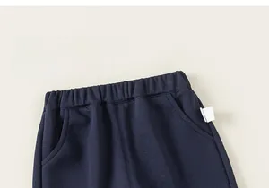 Detailed macro view of navy blue elastic waistband and knitted texture of kids trousers