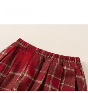 Detail view of girls red plaid pleated skirt with elastic waistband and wool texture