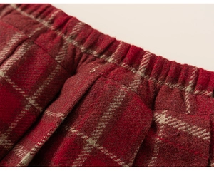 Detailed close-up of girls red plaid woolen skirt with elastic waist and pleats