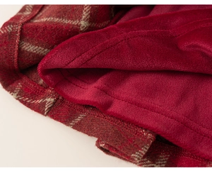 Detail of red plaid wool fabric with warm thickened fleece lining and fine stitching