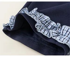 Detailed close-up of dark blue knit fabric with plaid ruffle edges and double stitching