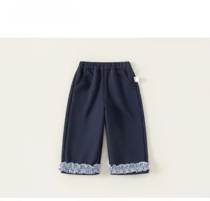 Detailed view of dark blue children trousers with blue-white checkered ruffled hems