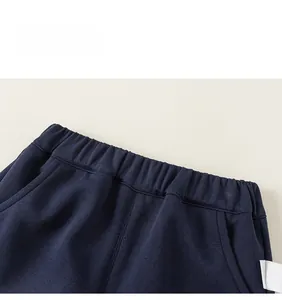 Detail showing elastic waistband and fine stitching on dark blue kids casual trousers