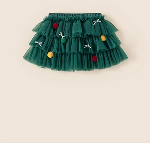 Détail de la jupe tutu en tulle vert foncé avec pompons et nœuds festifs
