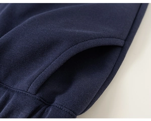 Detailed close-up of navy knit cotton fabric showing stitched pockets and ribbed cuffs