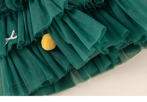 Détail d'une jupe en tulle vert foncé à plusieurs épaisseurs avec nœud en satin blanc