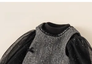 Close-up of girls' tweed dress featuring black tulle sleeves and a delicate bow detail