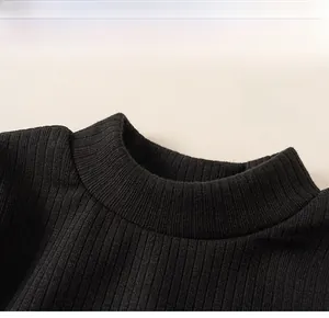 Detail of the classic crew neck and ribbed knit texture on a black girls' winter sweater