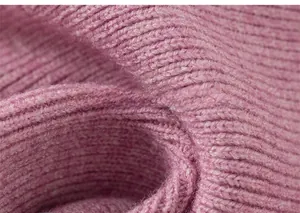 Close-up of pink ribbed knit fabric showing the soft texture of the girl's sweater dress