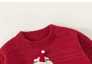 Detail of red knitted children's sweater featuring a 3D Santa Claus holiday decoration