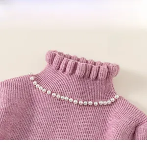 Detail of a purple knit dress featuring an elegant ruffled collar and white pearl decoration