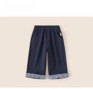 Detail view of navy blue girl pants with checkered ruffle hem and elastic waist