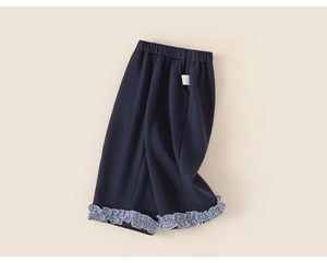 Detail of kids navy fleece pants showing the checkered ruffle hem and elastic waistband