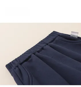 Detail showing elastic waistband and neat stitching on dark blue knit trousers for girls
