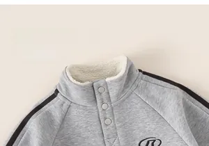 Detail of boys winter sweatshirt with fleece-lined stand collar and metal buttons