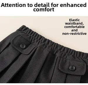 Detail of the elastic waistband and decorative pockets on a black pleated skirt