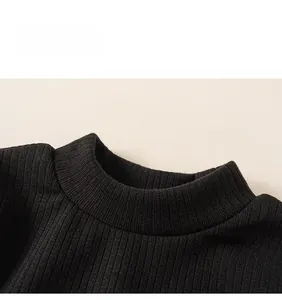 Detailed macro view of the ribbed knit neckline on the black long-sleeve winter dress