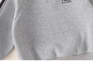 Detailed close-up of grey knitted sweater with Energy everyday print and striped design