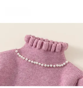 Close-up of pink knit dress collar with delicate ruffles and elegant pearl embellishments