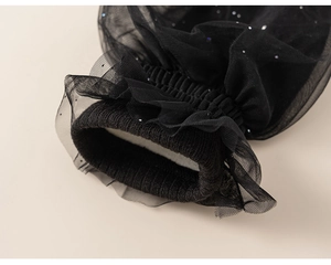 Detail of knit cuff with black layered mesh and sparkling blue and silver sequins