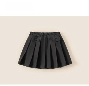 Detail of girls' black pleated skirt featuring elastic waist and buttoned pockets