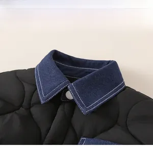 Detail of boys' quilted winter jacket featuring a stylish denim collar and chest pocket