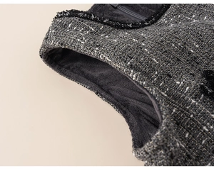 Detailed view of tweed fabric texture with warm lining and black lace trim