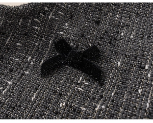 Macro detail of tweed fabric with metallic threads and a black velvet bow with glitter