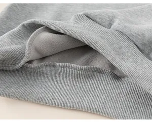 Detail of boys' grey winter sweatshirt showing thick fleece lining and ribbed hem