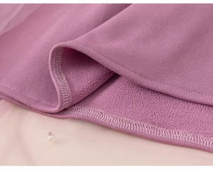 Close-up of purple knit fabric with warm fleece lining and pearl neck detail on girl's dress