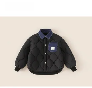 Detail of boys' black and blue quilted winter jacket with denim collar and button closure