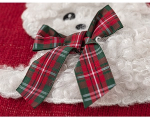 Close-up of girls' red knit sweater with fuzzy puppy patch and festive plaid bow detail
