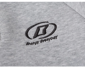 Detail of grey knitted sweatshirt featuring black B-logo and Energy Everyday embroidery