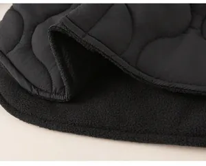 Detailed close-up of wave quilted black fabric with warm fleece lining for kids coat