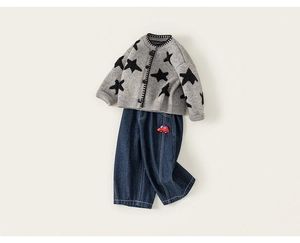 Detailoverzicht van grijs gebreid kindervest met sterren en donkerblauwe jeans met borduursel